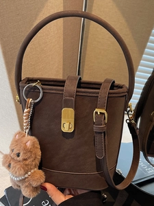 Sac seau vintage marron foncé avec détails dorés et charmant pendentif chiot