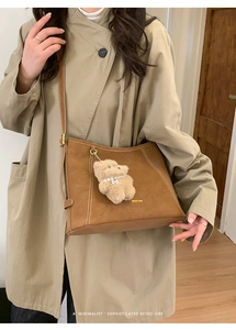 Détail du sac cabas en suédine marron avec surpiqûres et un charm ours en peluche