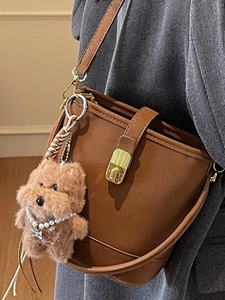 Sac seau rétro en cuir marron pour femme avec fermoir doré et accessoire peluche chiot