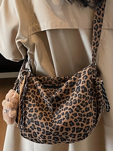 Leopard print pleated underarm tote bag with plush bear charm and woven tassel details