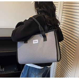 Close-up of large plaid tote bag with grey checkered fabric and black straps