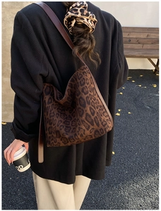 Close-up of leopard print shoulder bag with brown leather strap in autumn setting