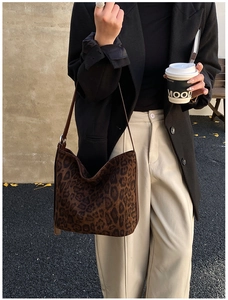 Detail of leopard print faux fur shoulder bag worn by model in vintage winter outfit