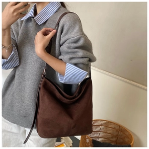 Brown suede hobo shoulder bag styled with casual knitwear for a daily commute look