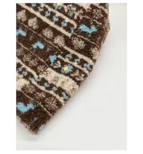 Close-up of plush knitted fabric texture with brown, beige and blue jacquard patterns