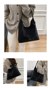 Detailed macro view of black suede leather tote bag showing textured finish and logo