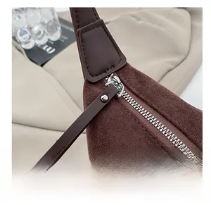 Close-up of smooth silver metal zipper on leopard print brown suede shoulder bag