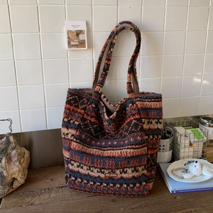 Detail of colorful plush tote bag with ethnic jacquard pattern and leather logo tag