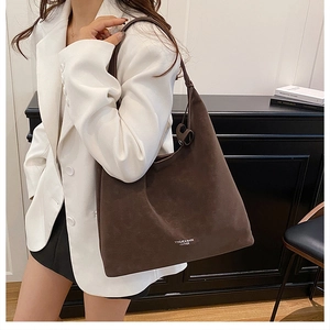 Brown suede tote bag side view on shoulder showing large capacity and soft texture