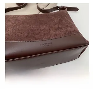 Detailed close-up of dark brown suede and smooth leather patchwork on shoulder bag