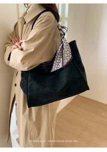 Detail of large black matte tote bag with paisley scarf decoration on shoulder strap