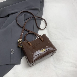 Dettaglio della borsa a secchiello marrone scuro coccodrillo con scritta dorata