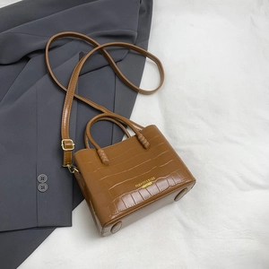 Borsa a secchiello marrone con stampa coccodrillo su abito grigio con tracolla regolabile