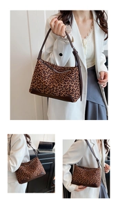 Detail view of brown leopard print shoulder bag with brown leather trim and metal zipper