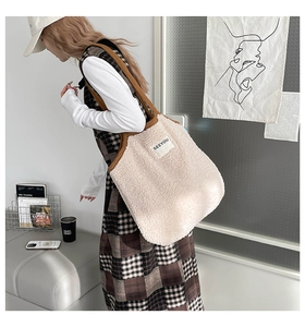 Détail du sac fourre-tout en fausse fourrure ivoire douce avec une bandoulière marron chic