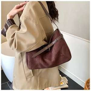 Detail of vintage brown suede tote bag with adjustable metal buckle on shoulder strap