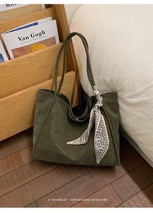Detail of vintage green leather tote bag featuring an elegant printed silk scarf accessory