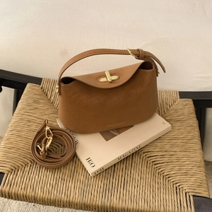 Détail du sac en similicuir marron caramel avec fermoir rotatif doré et logo