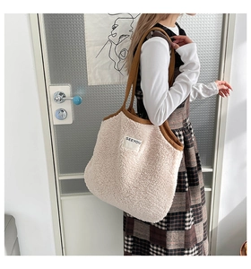 Détail du sac cabas en peau lainée beige avec anses marron et écusson SEEYOU