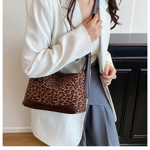 Detail view of a vintage leopard print shoulder bag with dark brown leather straps