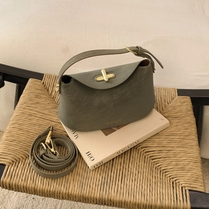 Détail du sac en cuir mat vert olive avec fermoir tournant doré et deux bandoulières