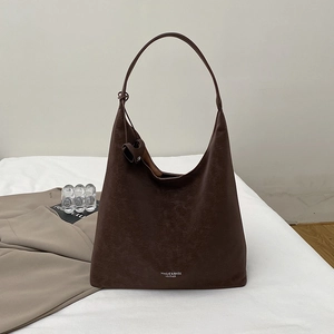 Close-up of deep brown hobo bag showing leather texture and printed logo on the bottom