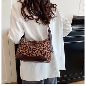Rear view of a stylish leopard print shoulder bag worn as an underarm baguette bag