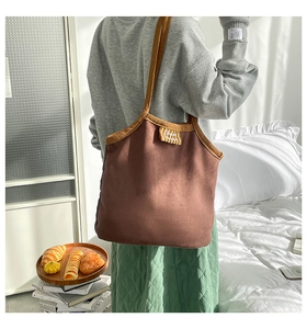 Vue détaillée du grand sac cabas en daim marron avec étiquette de marque et bandoulière