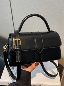 Minimalist black leather crossbody handbag with top handle and gold hardware detail