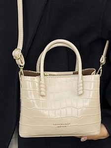 Elegante borsa a secchiello beige con motivo coccodrillo, manici e tracolla regolabile