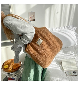 Gros plan du sac cabas en polaire marron avec broderie de l'écusson de lettres SEEYOU
