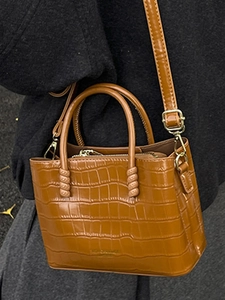 Elegante borsa a secchiello marrone caramello con motivo coccodrillo e dettagli dorati