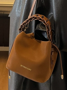 Brown bucket bag with woven handle and drawstring closure for women in 2025 style