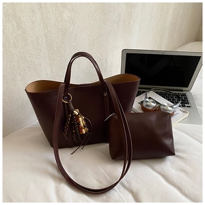 Deep brown tote bag set with matching pouch and bead charm in a lifestyle office setting