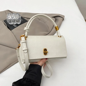 Detailed view of cream white leather handbag with elegant vintage gold metal twist lock