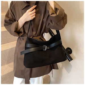 Detailed view of black matte tote bag with polished leather strap and silver buckle
