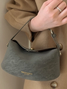 Sac à bandoulière minimaliste en cuir gris foncé avec détails dorés et logo embossé