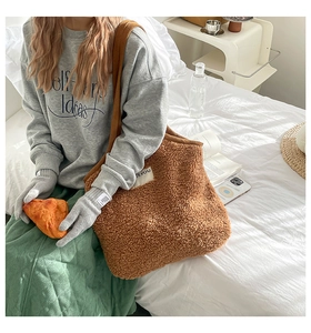 Grand cabas en polaire marron présenté dans un décor hivernal avec des gants en tricot