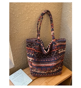 Close-up of plush tote bag with ethnic jacquard pattern in navy and orange wool
