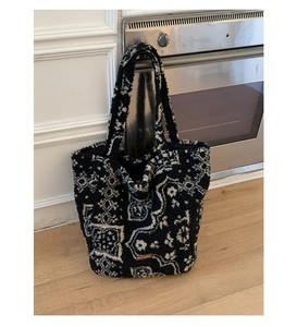 Detail of plush tote bag showing retro ethnic pattern and brown leather logo patch