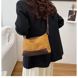 Detail of crossbody bag in ginger frosted suede and dark brown leather on model