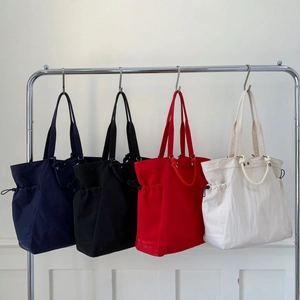 Collection of large canvas tote bags in navy, black, red and cream with side drawstrings