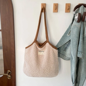 Détail d'un sac cabas en polaire beige avec bordure marron et écusson SEEYOU brodé