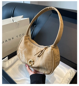 Détail du sac à bandoulière en cuir plissé beige avec boucle en métal en forme de C