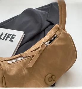 Gros plan du sac porté épaule kaki avec fermeture éclair argentée et similicuir texturé