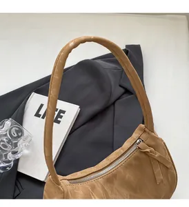 Vue détaillée du sac porté épaule en cuir caramel avec texture vintage et zip argenté