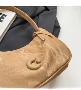 Gros plan du sac hobo kaki avec boucle anneau 3D et texture en cuir synthétique souple