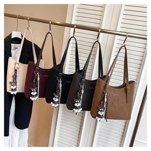Detail showing high-capacity leather tote bags in five colors with dog charms