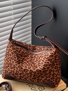 Chic leopard print underarm bag with dark brown leather trim and adjustable strap