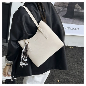 Chic cream tote bag with dog charm shown on shoulder for professional daily commute
